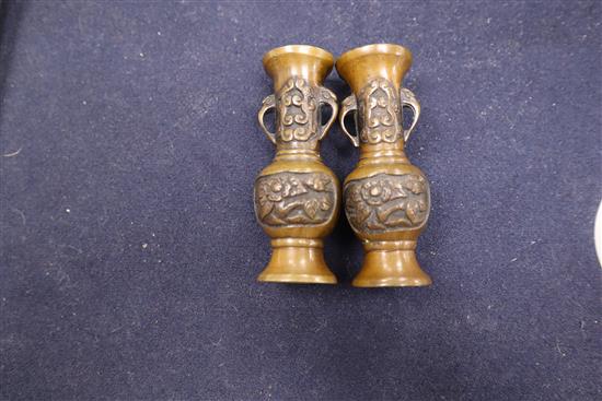 A Chinese bronze bell, a pair of miniature bronze vases and a blue and white cup with Kangxi mark tallest 15cm